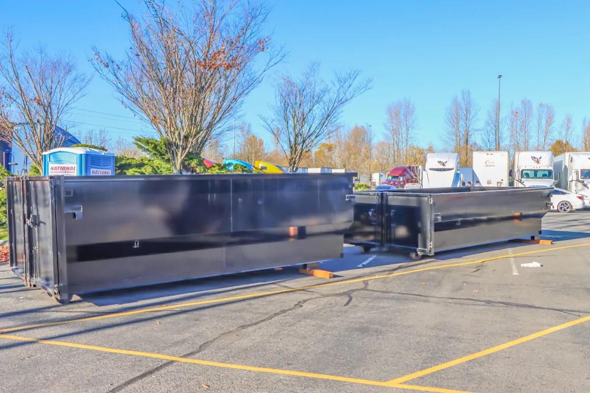 Professional dumpster rental service with roll-off container on residential driveway in Red Bank